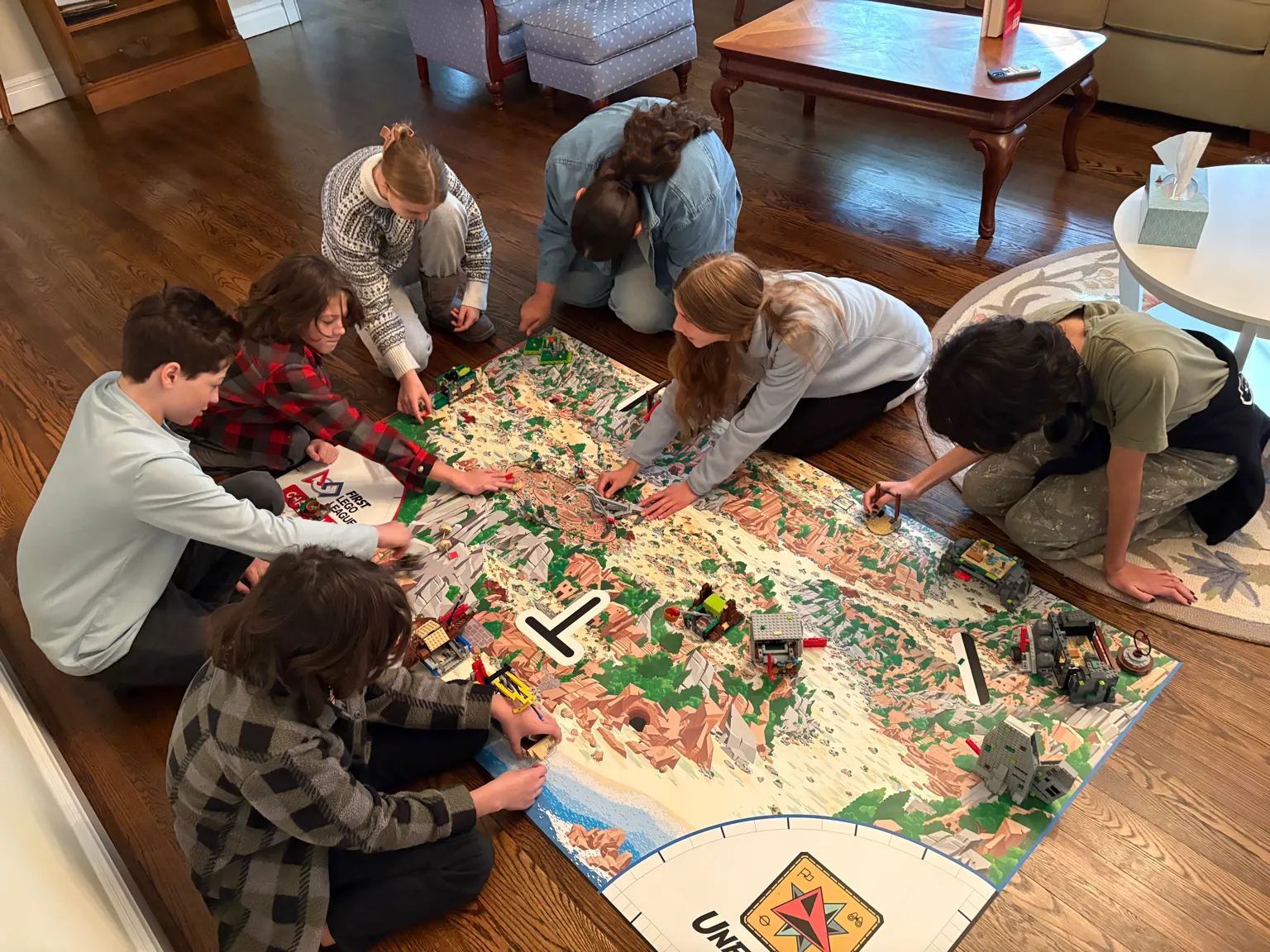 Four students focused on one corner of the FLL field