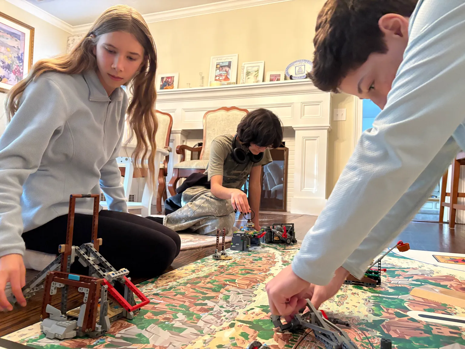 Students from Team 5016 working together on an FLL field kit in a living room