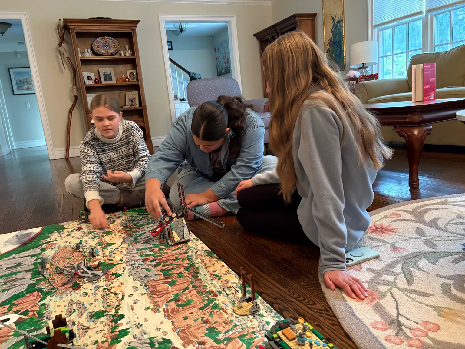 Three students arranging LEGO mission models on the FLL mat